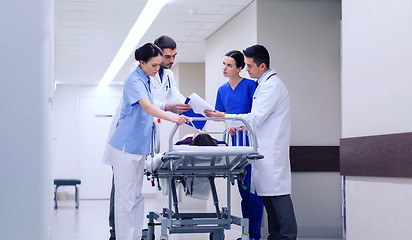 Image showing medics with woman on hospital gurney at emergency