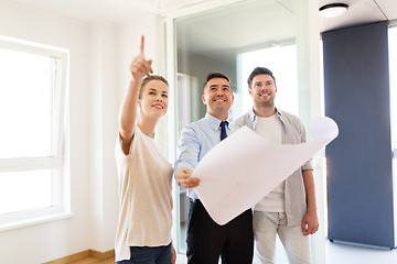 Image showing realtor showing blueprint of new home to couple