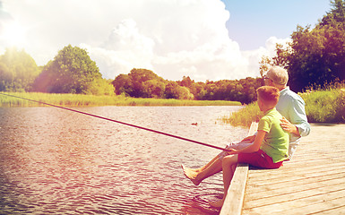 Image showing grandfather and grandson fishing on river berth