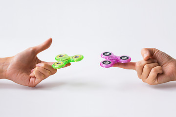 Image showing close up of two hands playing with fidget spinners