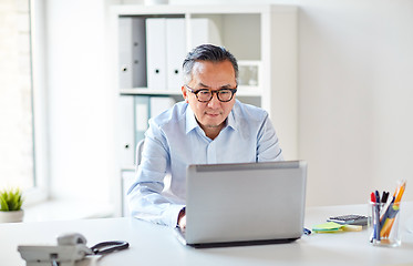 Image showing businessman in eyeglasses with laptop office