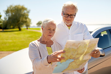 Image showing senior couple at car looking for location on map