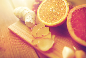 Image showing citrus fruits, ginger and garlic on wood