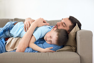 Image showing happy father and son sleeping on sofa at home