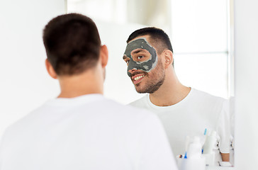 Image showing young man with clay mask on face at bathroom