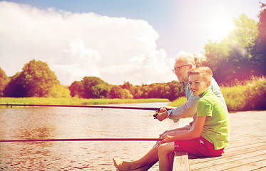 Image showing grandfather and grandson fishing on river berth