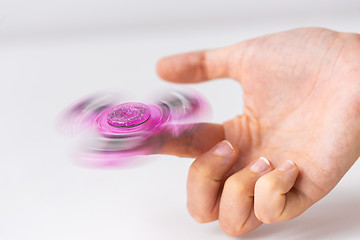 Image showing close up of hand playing with fidget spinner