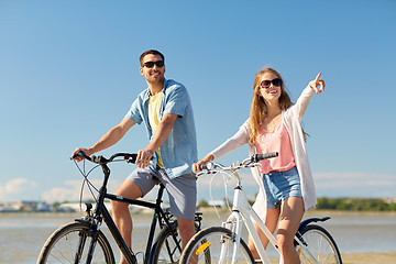 Image showing happy young couple riding bicycles at seaside