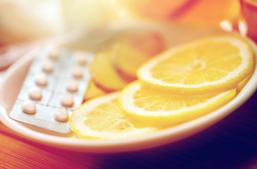 Image showing lemon slices, pills and ginger on plate