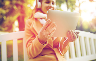 Image showing woman with tablet pc and headphones in autumn park