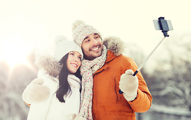 Image showing happy couple taking selfie by smartphone in winter