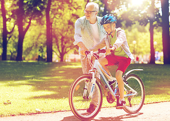 Image showing grandfather and boy with bicycle at summer park