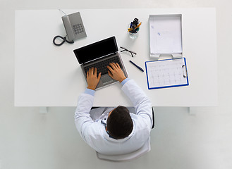 Image showing doctor with cardiogram and laptop at clinic