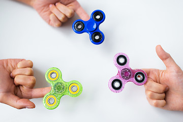 Image showing close up of hands playing with fidget spinners