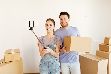 Image showing happy couple with boxes moving to new home