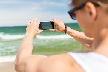 Image showing man with smartphone photographing on summer beach