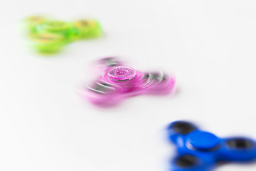 Image showing three spinning fidget spinners on white background