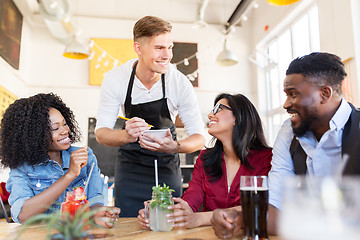 Image showing waiter and friends with menu and drinks at bar