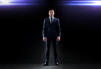 Image showing businessman in suit over black with laser light