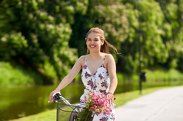 Image showing happy woman riding fixie bicycle in summer park