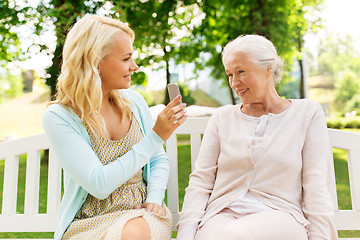 Image showing daughter and senior mother with smartphone at park