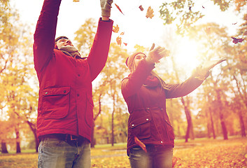 Image showing happy young couple throwing autumn leaves in park