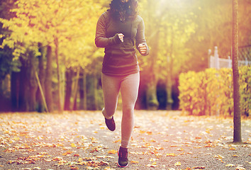 Image showing close up of young woman running in autumn park