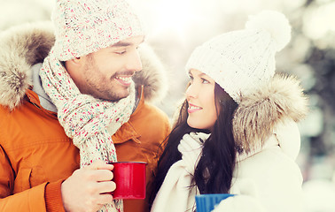 Image showing happy couple with tea cups over winter landscape