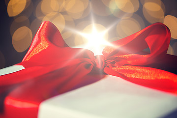 Image showing close up of christmas gift with bow over lights