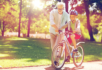 Image showing grandfather and boy with bicycle at summer park