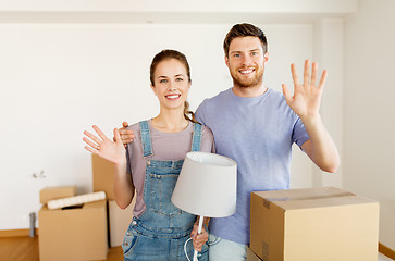 Image showing couple with boxes and lamp moving to new home