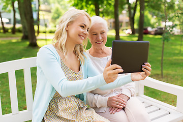 Image showing daughter with tablet pc and senior mother at park