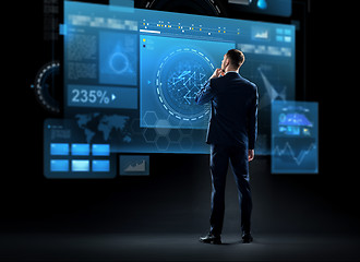 Image showing businessman looking at virtual screen from back