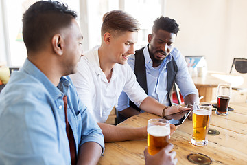 Image showing male friends with tablet pc drinking beer at bar