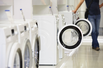 Image showing washing machines in appliance store and defocused buyer