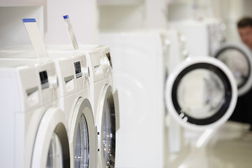 Image showing washing machines in appliance store and defocused buyer