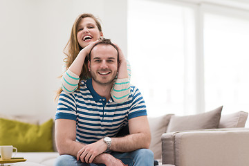 Image showing young handsome couple hugging on the sofa