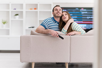 Image showing Young couple on the sofa watching television