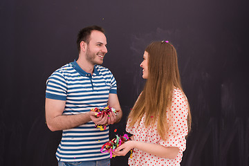 Image showing couple blowing confetti in the air isolated over gray