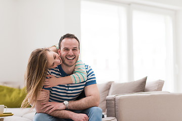 Image showing young handsome couple hugging on the sofa