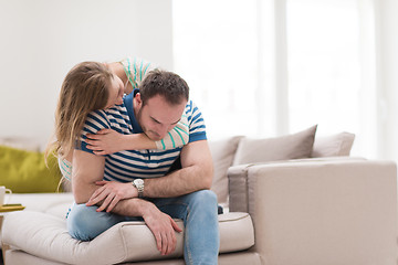 Image showing young handsome couple hugging on the sofa