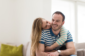 Image showing young handsome couple hugging on the sofa