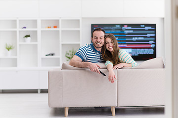 Image showing Young couple on the sofa watching television