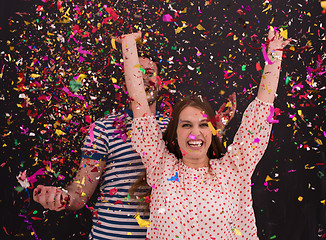 Image showing couple blowing confetti in the air isolated over gray