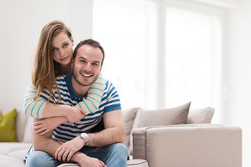 Image showing young handsome couple hugging on the sofa