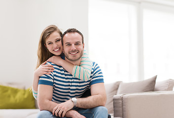 Image showing young handsome couple hugging on the sofa