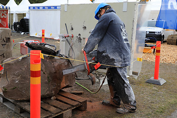 Image showing Man Saws Granite Stone with ICS Chainsaw