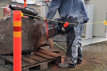 Image showing Man Saws Granite with ICS Chainsaw