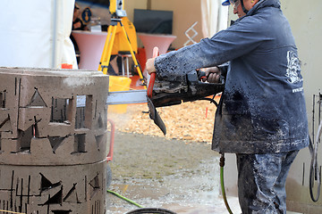 Image showing Man Saws Concrete with ICS Chain Saw