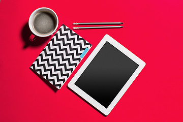 Image showing Modern red office desk table with smartphone and cup of coffee.